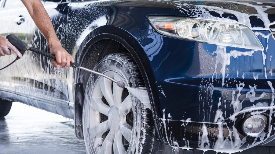 man-washes-foam-out-car-with-pressure-water_438099-2661